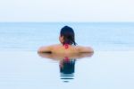 Woman Relaxing Infinity Swimming Pool Stock Photo