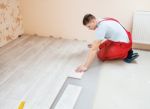 Handyman Laying Down Laminate Flooring Boards Stock Photo