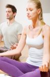 Couple Sitting On Floor Doing Yoga Stock Photo