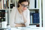 Young Working Woman Reading The Newspaper At Office Stock Photo