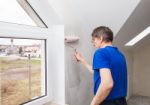 Elderly Worker Painting Wall With Glue Stock Photo