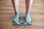 Woman's Legs Standing On The Scales Stock Photo