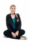 Cheerful Teenager Seated On Floor, Legs Crossed Stock Photo