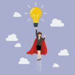 Business Woman Superhero Holding Creative Lightbulb Stock Photo