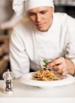 Chef Decorating Pasta Salad With Herbal Leaves Stock Photo