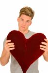 Young Man With Heart Shaped Pillow Stock Photo