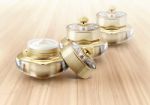 Golden Crown Cosmetic Jar On Wood Background Stock Photo