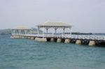 White Long Wooden Bridge Pavilion Into The Sea, Cargo Ships In The Sea Stock Photo