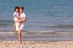 Asian Woman Hold The Boy On Beach Stock Photo