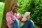 Handsome Man With Tablet In The Park Stock Photo