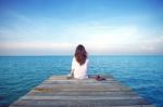 Girl Sitting Alone On A The Wooden Bridge On The Sea. Vintage Tone Style. (frustrated Depression) Stock Photo