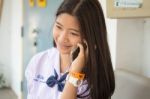 Portrait Of Thai Student Teen Beautiful Girl Using Her Phone And Smile Stock Photo