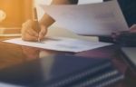 Woman Standing And Writing Document Hand  At Desk Stock Photo