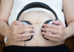 Pregnant Woman Listen To The Music Stock Photo