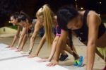 Group Of Girls Doing Push-ups At Night Stock Photo