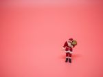 Miniature Santa Claus On Pink Background. Christmas And Happy Ne Stock Photo