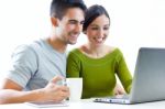 Happy Young Couple Browsing Internet At Home Stock Photo