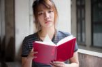 Portrait Of Thai Adult Beautiful Girl Reading Red Book Stock Photo