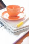 Laptop With Coffee Cup And Notepad On Desk Stock Photo