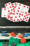 Poker Chips And Cards And A Laptop On Casino Baize Stock Photo