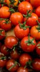 Cherry Tomatoes On Display On Wooden Chopping Board And Wooden Table Stock Photo