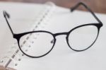 Eyeglasses On Opened Spiral Notebook Stock Photo