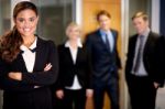 Business Woman Posing With Smart Associates Behind Stock Photo