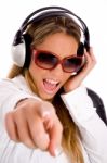 Portrait Of Smiling Female Listening Music And Pointing At Camera Stock Photo