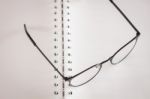 Eyeglasses On Opened Spiral Notebook Stock Photo