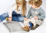 Girl And Boy Near Laptop Stock Photo