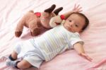 Hispanic Baby With Teddy Bear Laying On Bed Stock Photo