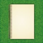 Notebook With White Page On Green Grass Background Stock Photo