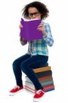 Young Kid Concentrating While Reading A Book Stock Photo