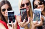 Three Friends Taking Photos With A Smartphone Stock Photo