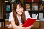 Portrait Of Thai Adult Student University Uniform Beautiful Girl Reading Red Book Stock Photo