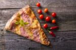 Pizza Cut On Wooden Table, Cherry Tomato And Hot Peppers Stock Photo