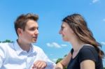 Young Man And Woman In Love Conversating With Blue Sky Stock Photo