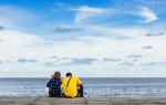 Couple Sitting And Looking The Sea Stock Photo