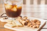 Glass Of Black Iced Coffee With Some Snack Stock Photo