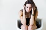 Depressed Young Woman Sitting At Home Stock Photo