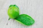 Lime And Leaves On Wood Stock Photo