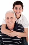 Grandfather Piggybacking His Grandson Stock Photo