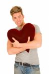 Standing Young Man Embracing Pillow Stock Photo