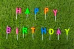 Colorful Happy Birthday Candles On Field Stock Photo