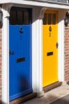 Shadow Approaching Blue And Yellow Doors Stock Photo