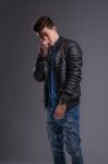 Casual Young Man In Black Leather Jacket And Denim Jeans Stock Photo