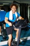 Fitness Man Riding A Static Bike Inside Gym Stock Photo