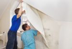 Two Workers Smoothing Wallpaper Stock Photo