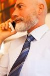 Middle-aged Businessman Listening On Smartphone At Home Stock Photo