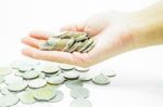 Hand On Thai Baht Coins On White Table Background Stock Photo